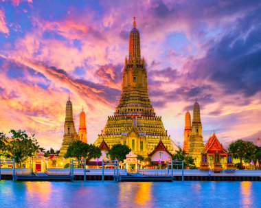 Tayland 'da gün batımında Bangkok' taki Wat Arun tapınağı. Chao praya nehri Bangkok, alacakaranlık vakti, renkli bir gökyüzü ve tapınağın üzerindeki ışıkla.