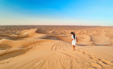 Dubai çöl kum tepeleri, Dubai çölünde safari yapan Asyalı bir kadın, Birleşik Arap Emirlikleri tatili, Dubai 'de tatilde olan Dubai kumullarında yürüyen bir kadın. 