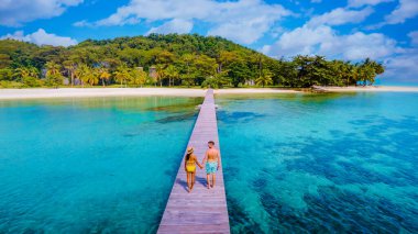 Tayland 'da tropikal bir adada tahta bir iskelede, Koh Mak Trat yakınlarında, Tayland' da tatil tatilleri sırasında, tropik bir adada, tahta bir iskelede, bir çift ve bir kadın.