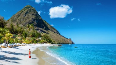 St. Lucia Karayipleri, Saint Lucia Karayip Okyanusu 'nda tatilde olan bir kadın, sahilde yürüyen kırmızı elbiseli bir Asyalı kadın.