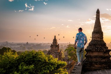 Bagan Myanmar, genç adamlar eski bir pagoda tapınağının tepesinde güneşin doğuşunu izliyorlar. Myanmar Asya 'da tatilde olan Avrupalı bir adam Bagan' ın tarihi mekanını ziyaret etti