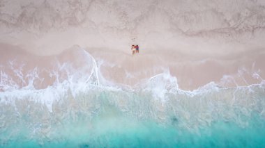 Tatil sırasında Phuket Tayland 'da Özgürlük Sahili' nde bir çiftin insansız hava aracı görüntüsü, Tayland sahilinin yukarısından insanlarla tropik plajın üst görüntüsü.