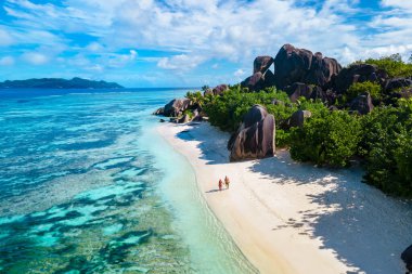 Anse Source d 'Argent Beach La Digue Seychelles, Seyşeller' de lüks bir tatil sırasında tropikal bir plajda yaşayan genç bir çift. Tropik sahil Anse Kaynağı d 'Argent La Digue Seyşeller
