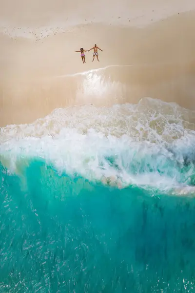 熱帯のビーチに横たわる男女 セーシェル ココス島セーシェルの熱帯ビーチで上からのドローンビュー トロピカルビーチで上から眺める 休暇中のカップル — ストック写真