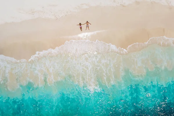 熱帯のビーチに横たわる男女 セーシェルコス島のトロピカルビーチで上からドローンビュー 熱帯のビーチで上から眺める 休暇の熱帯島でカップル — ストック写真