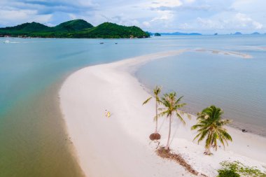 Koh Yao Tayland adasında kumsalda yürüyen bir çift kadın ve erkek. Beyaz kum ve palmiye ağaçları olan bir plaj. Laem 'in Ko Yao Yai plajı vardı.