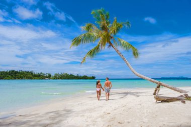Tropik Koh Kood Adası veya Koh Kut Tayland. Tayland 'da tatilde olan birkaç erkek ve kadın sahilde yürüyor, Tatil konsepti adası Doğu Tayland Trang' da zıplıyor