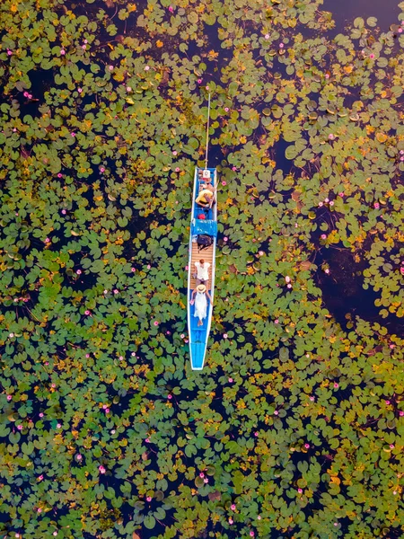 赤い蓮の海 ノンハルン湖 ウドンタニ イサリアのレッドロータス湖で日の出にボートで男性と女性のカップル ドローン空中ビュー — ストック写真