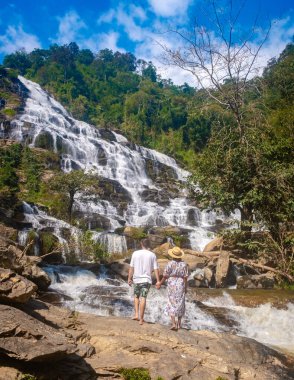 Mae Ya Waterfall Doi Inthanon Ulusal Parkı Tayland Chiang Mai, Tayland 'da Doi Inthanon Ulusal Parkı' nda bulunan güzel bir şelaledir. Bir çift adam ve bir kadın Tayland 'da bir şelaleyi ziyaret ediyorlar.