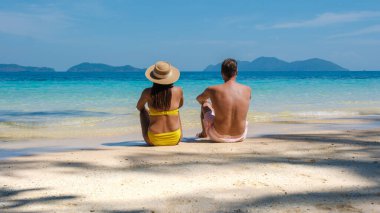 Koh Wai Adası Trat Tayland, Koh Chang yakınlarında teneke bir tropikal adadır. Tayland 'da lüks bir tatil sırasında tropikal sahilde bir çift genç erkek ve kadın, kumsalda uzanan bir çift.