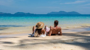 Koh Wai Adası Trat Tayland, Koh Chang yakınlarında teneke bir tropikal adadır. Tayland 'da lüks bir tatil sırasında plajda dinlenen genç bir çift kadın ve erkek.