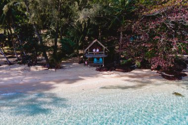 Koh Wai Adası Trat Tayland. Kumsaldaki ahşap bambu kulübesi. Tayland 'da tropik bir adada genç bir çift kadın ve erkek.