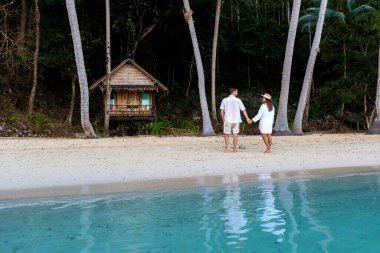Koh Wai Adası Trat Tayland, Koh Chang yakınlarında teneke bir tropikal adadır. Kumsaldaki ahşap bambu kulübesi. Tayland 'da tropik bir adada genç bir çift kadın ve erkek.