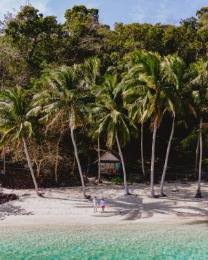 Koh Wai Adası Trat Tayland, Koh Chang yakınlarında teneke bir tropikal adadır. Kumsaldaki ahşap bambu kulübesi. Bir çift genç adam ve kadın sabah vakti Tayland 'da tropik bir adada.