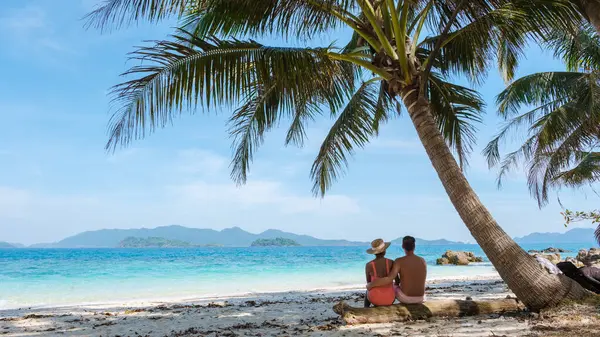 高伟岛是靠近高昌的一个微小的热带岛屿 一对年轻夫妇坐在热带海滩上享受泰国的豪华假期 一对夫妇坐在棕榈树下 — 图库照片
