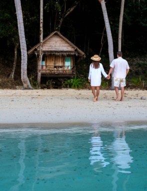 Koh Wai Adası Trat Tayland, Koh Chang yakınlarında. Kumsaldaki ahşap bambu kulübesi. Tayland 'da tropikal bir adada odaktan uzak genç bir çift okyanusa odaklanıyor.