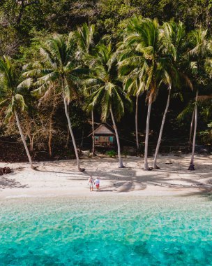 Koh Wai Adası Trat Tayland, sahilde ahşap bambu kulübesi. Tayland 'da tropikal bir adada, kumsalda palmiye ağaçları ve hindistan cevizi renkli okyanusları olan genç bir çift.