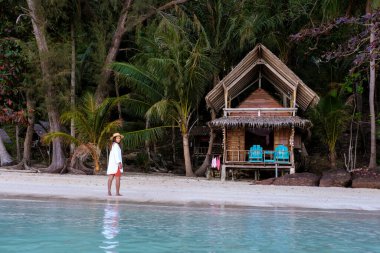 Koh Wai Adası Trat Tayland, Koh Chang yakınlarında teneke bir tropikal adadır. Kumsaldaki ahşap bambu kulübesi. Tayland 'da tropik bir adada genç bir Asyalı kadın.