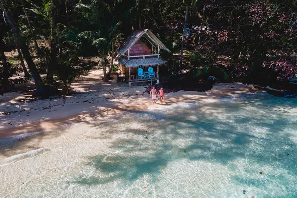 高伟岛是靠近高昌的一个微小的热带岛屿 海滩上的木制竹屋平房 泰国热带岛屿上的一对年轻夫妇 — 图库照片
