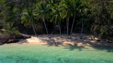 Koh Wai Adası Trat Tayland, Koh Chang yakınlarında teneke bir tropikal adadır. Kumsaldaki ahşap bambu kulübesi. Tayland 'da tropik bir adada genç bir çift kadın ve erkek.