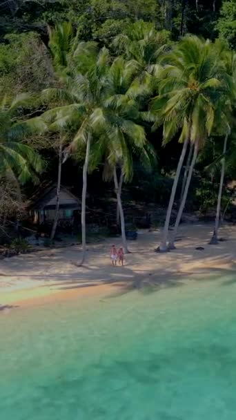 Koh Chang近くのコワイ島トラットタイ ビーチの木製竹小屋バンガローとタイの熱帯島のヤシの木とビーチを歩く若い男女 — ストック動画