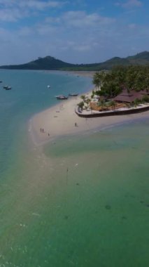 Koh Muk, tropik bir ada. Palmiye ağaçları, yumuşak beyaz kum ve turkuaz renkli bir okyanus. Koh Mook 'ta tatilde olan bir çift erkek ve kadın Trang Tayland' daki Andaman Denizi 'nde.