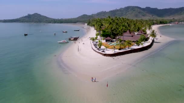 ヤシの木と柔らかい白い砂を持つ熱帯の島コムムクは タイのアンダマン海のコモク島の海を着色しました ビーチを歩く男性と女性のカップル — ストック動画