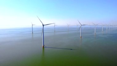 Hollanda 'da mavi gökyüzü yeşil enerji kavramına sahip elektrik üreten yel değirmeni türbinleri