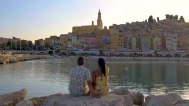 Günbatımında Fransız Riviera Fransa 'sındaki renkli Menton kasabası. Avrupa yazı boyunca Menton Fransa 'yı ziyaret eden çeşitli erkek ve kadınlar