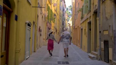 Günbatımında Fransız Riviera Fransa 'sındaki renkli Menton kasabası. Avrupa yazı boyunca Menton Fransa 'yı ziyaret eden çeşitli erkek ve kadınlar, eski Menton kentinde yürüyen bir çift.