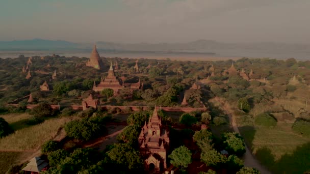 バガン ミャンマー 古いバガンの歴史的なユネスコの遺跡で寺院や古い塔でドローン エアリアル ビューの日の出 日光を眺める寺院の上に夫婦と女性 — ストック動画