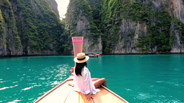 タイのクフィピで長いテールボートの前にアジアの女性 マヤベイコピピへのボート旅行中にタービューズ色の海でパイルシュラグーンでボートの前に女性 — ストック動画
