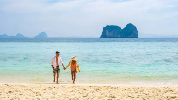 一对夫妇在Koh Ngai岛的热带海滩上散步 男人和女人在海边 背景是安达曼海的热带石灰岩悬崖 — 图库照片