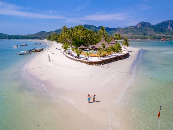 在泰国的一个热带度假期间 一对男女在海滩上散步 在泰国的一个热带小岛上 有棕榈树 柔软的白沙滩和一个草屋色的海洋 — 图库照片