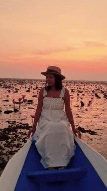 Isaan 'daki Kızıl Nilüfer Gölü' nde gün doğumunda teknede bir kadın, Kızıl Nilüfer Denizi, Nong Harn Gölü, Udon Thani, Tayland