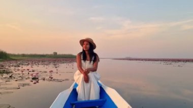 Isaan 'daki Kızıl Nilüfer Gölü' nde gün doğumunda teknede bir kadın, Kızıl Nilüfer Denizi, Nong Harn Gölü, Udon Thani, Tayland