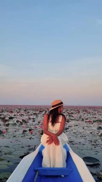 赤い蓮の海 ノン湖 ウドンタニ イタリアのレッドロータス湖の日の出にボートでアジアのタイの女性 — ストック動画