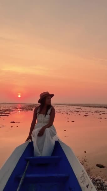 赤い蓮の海 ノン湖 ウドンタニ イサリアの赤いロータス湖の日の出にボートで白いドレスを持つアジアの女性 — ストック動画