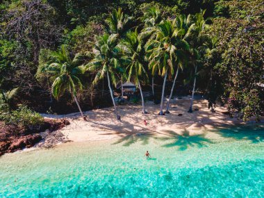 Koh Wai Adası Trat Tayland, Koh Chang yakınlarında teneke bir tropikal adadır. Kumsaldaki ahşap bambu kulübesi. Tayland 'da tropik bir adada genç bir çift kadın ve erkek.