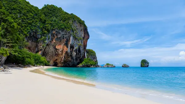 翠绿翠绿的热带海滩 背景上有雄伟的岩石结构 水晶般清澈 蓝天和郁郁葱葱的绿色植物构成 — 图库照片