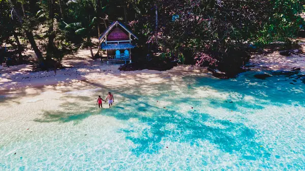 俯瞰一对夫妇在热带海滩上与棕榈树和一个木制竹屋平房 Koh Wai Island Trat Thailand 海滩上年轻男女的无人驾驶飞机瞄准镜 — 图库照片