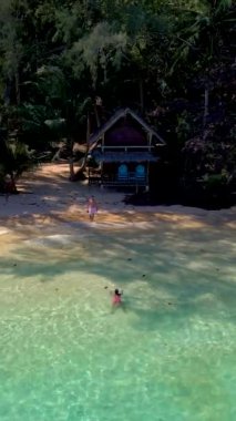 Okyanusta yüzmenin tadını çıkaran doğal manzara, ağaçlar ve kıyı arazileriyle çevrili tuhaf bir ev, sakin ve sakin bir ortam yaratıyor, Koh Wai, Tayland