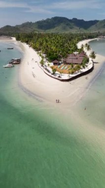 Kristal berrak sularla çevrili küçük bir adanın nefes kesici hava manzarası, yemyeşil bitkiler ve ağaçlar, kıyı şeridi boyunca kumlu plajlar, Koh Mook, Tayland