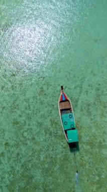 Uzun kuyruklu bir tekne, gözün görebildiği kadar sıvı ile çevrili olarak geniş okyanusta yelken açar. Su nakliyatının muhteşem manzarası Koh Kradan, Tayland