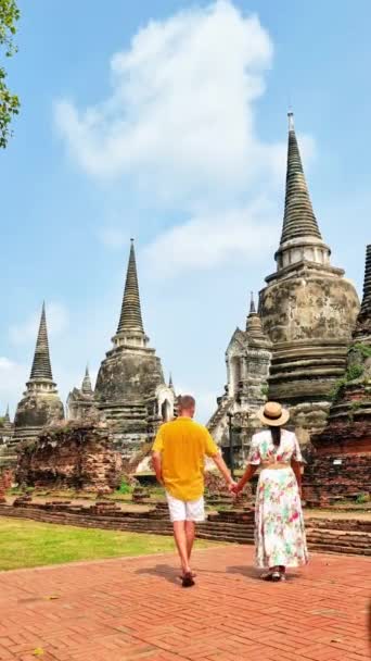 タイのアユタヤ空に浮かぶ木々と雲に囲まれた静かな自然環境に囲まれた神殿の前に男女が手を差し伸べています — ストック動画