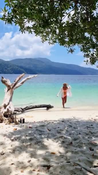 Een Vrouw Een Bikini Slentert Het Zandstrand Met Azuurblauw Water — Stockvideo
