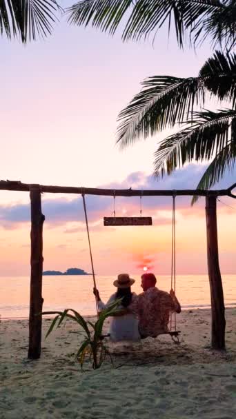 Casal Está Relaxando Balanço Pela Praia Pôr Sol Cercado Por — Vídeo de Stock