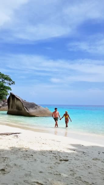 海岸や海洋の風景に囲まれた風光明媚なビーチを散策するカップル タイの海辺シミラン諸島でゆったりと旅行を楽しむ — ストック動画
