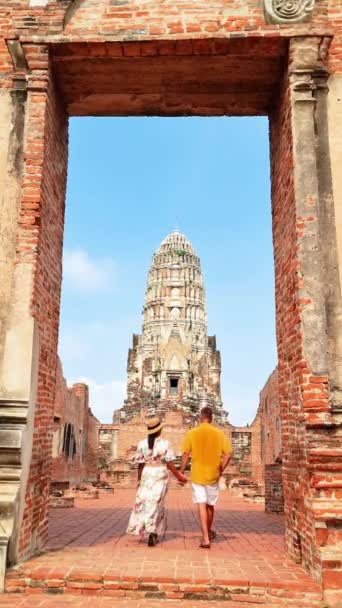 カップルは 寺院に向かって空の下のレンガのアーチウェイを散策 タイの記念碑のファサードアーユタヤに使用される建物の材料の対称性と芸術の完璧な写真 — ストック動画