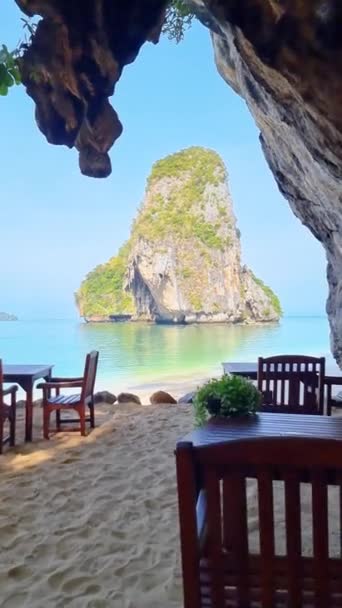 泰国克拉比 一个宁静的视频记录了一个有山地背景的海滩 一个海洋岩层和一个有桌子和椅子的海滨洞穴的美 — 图库视频影像
